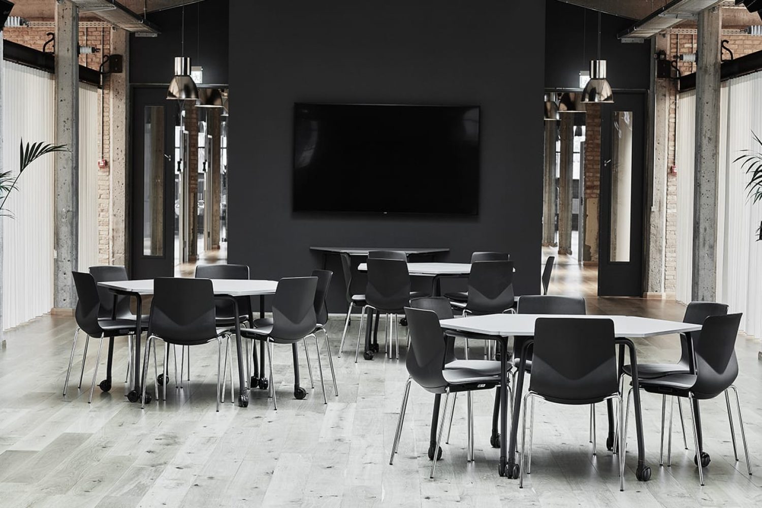 A black and white conference room with tables and office desk chairs.