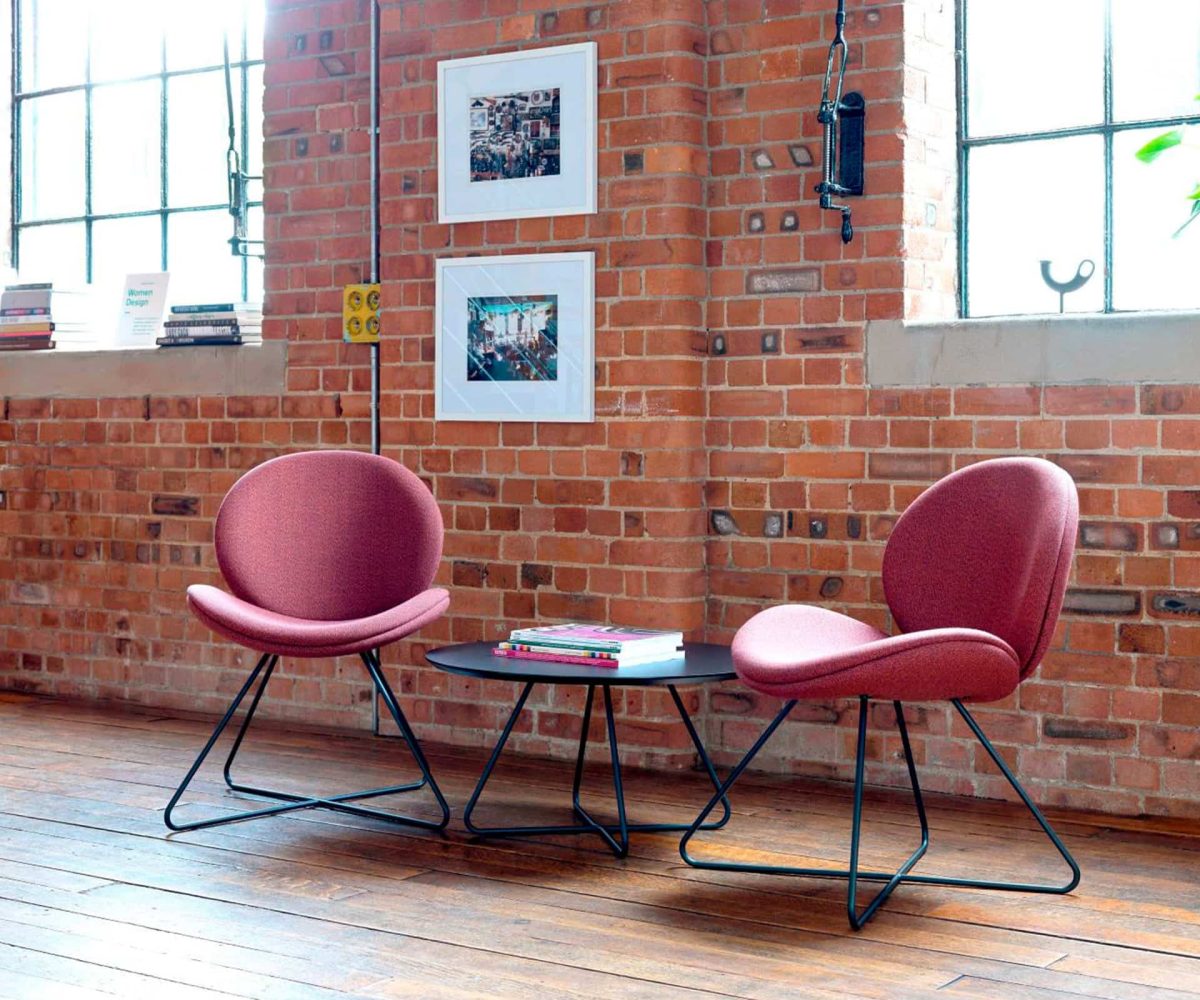 A room with two lounge chairs for offices and a table.