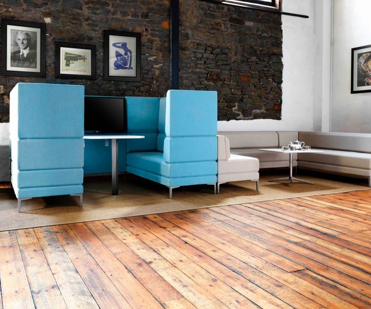 Blue office work booths in a room with a wooden floor.