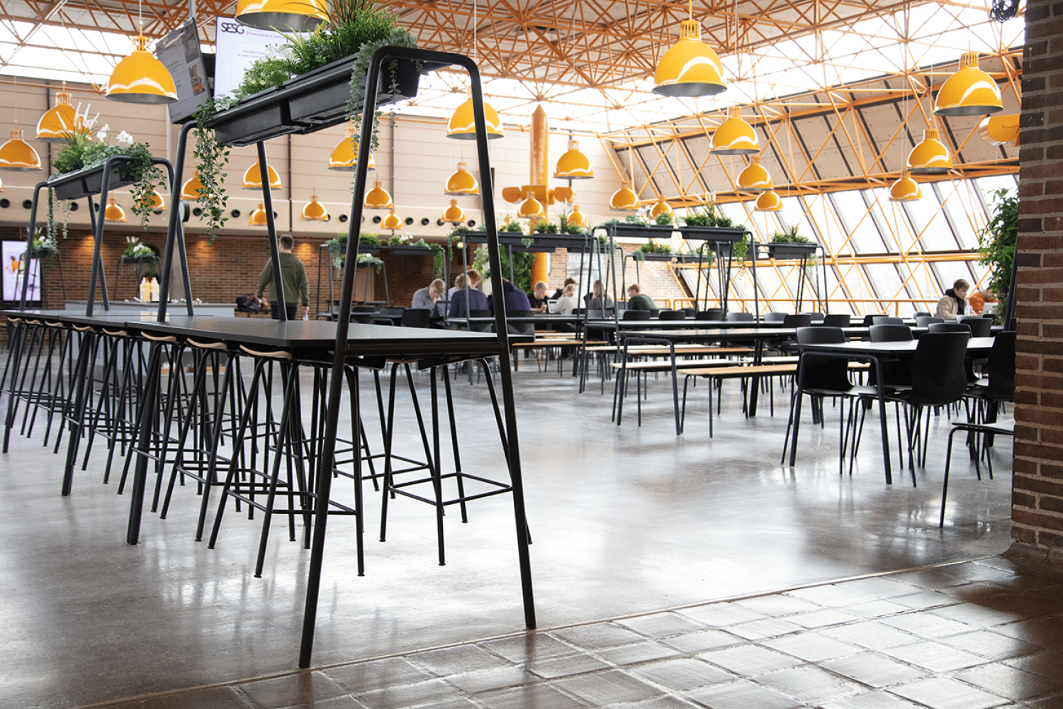 The interior of a canteen with canteen furniture, community tables and chairs.