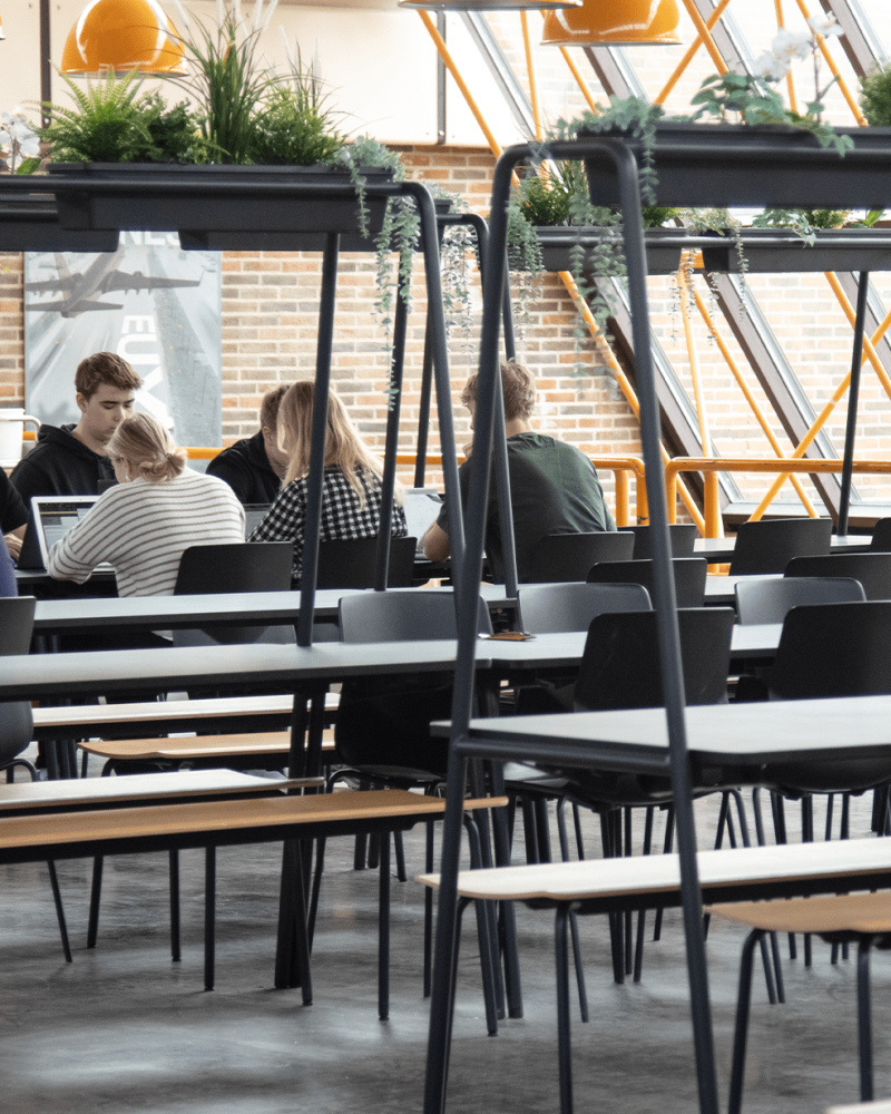 The interior of a canteen with canteen furniture, community tables and chairs.