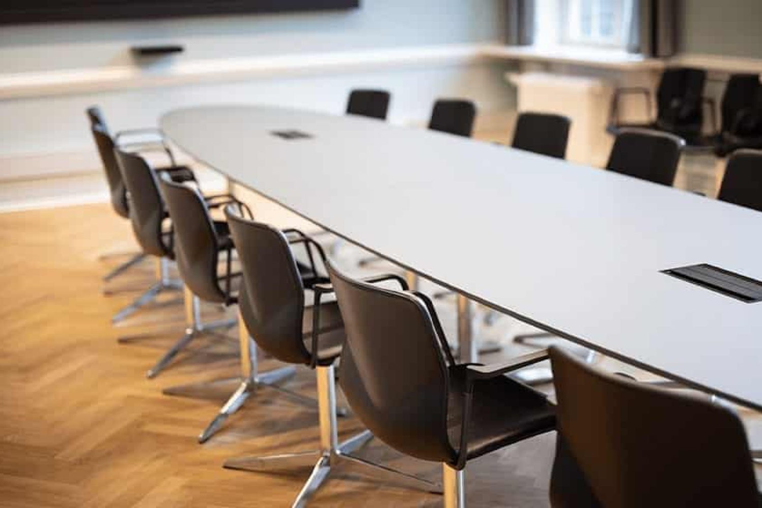 A conference room with a long designer office table and chairs.