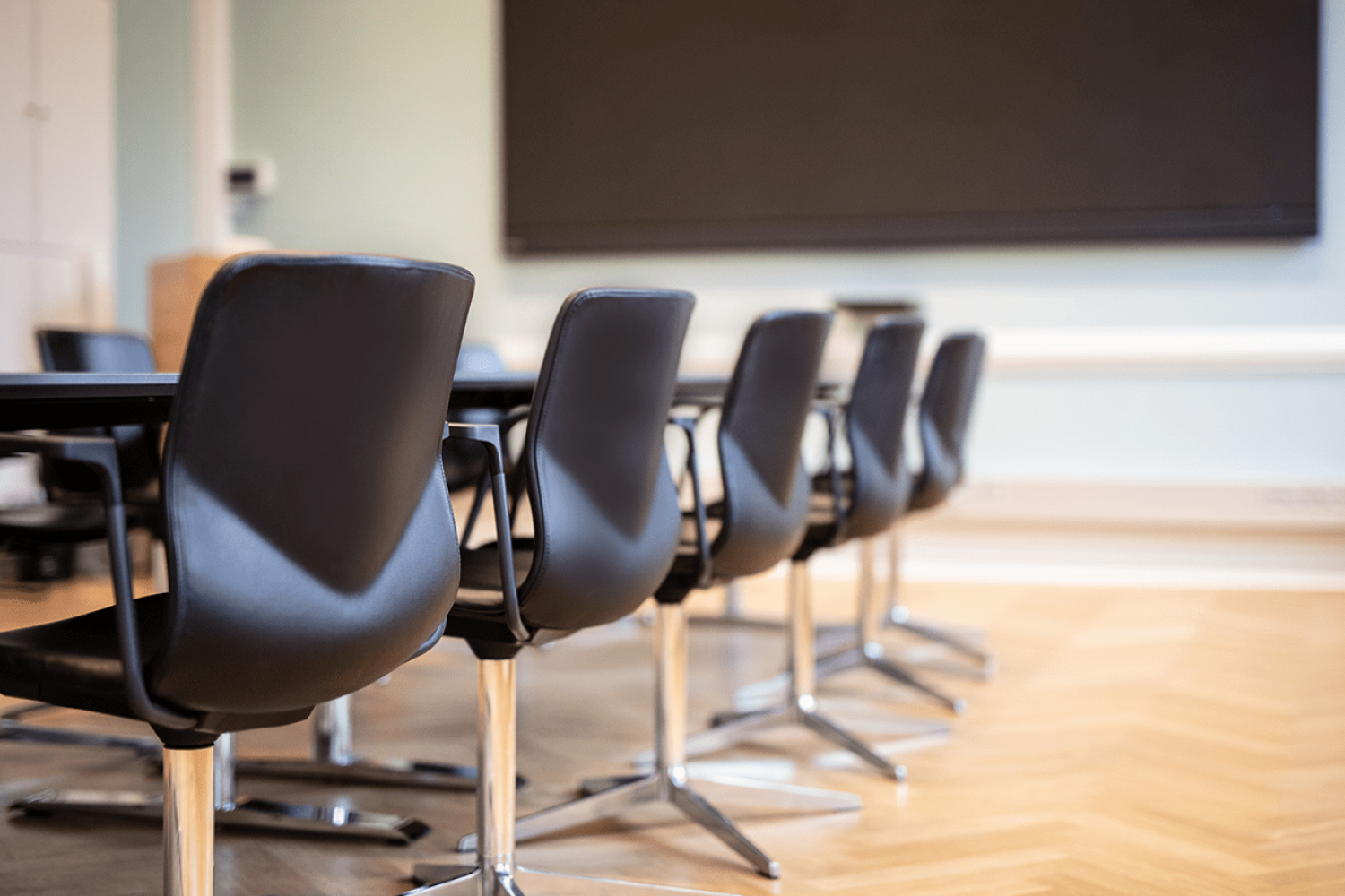 A conference room with a long designer office table and chairs.