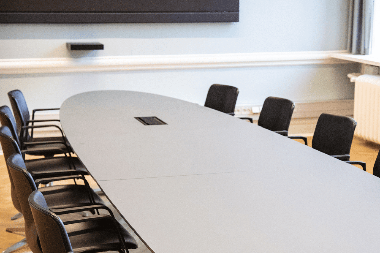 A conference room with a long designer office table and chairs.