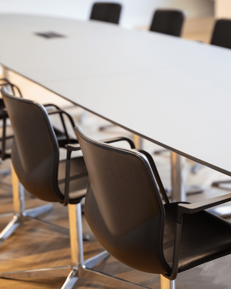 A conference room with a long designer office table and chairs.