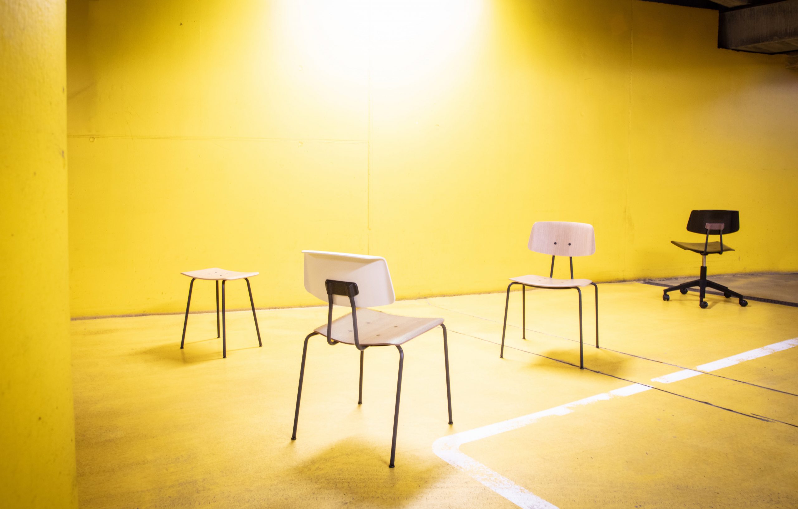 A group of Share office desk chairs and office stools and office benches on a yellow floor.