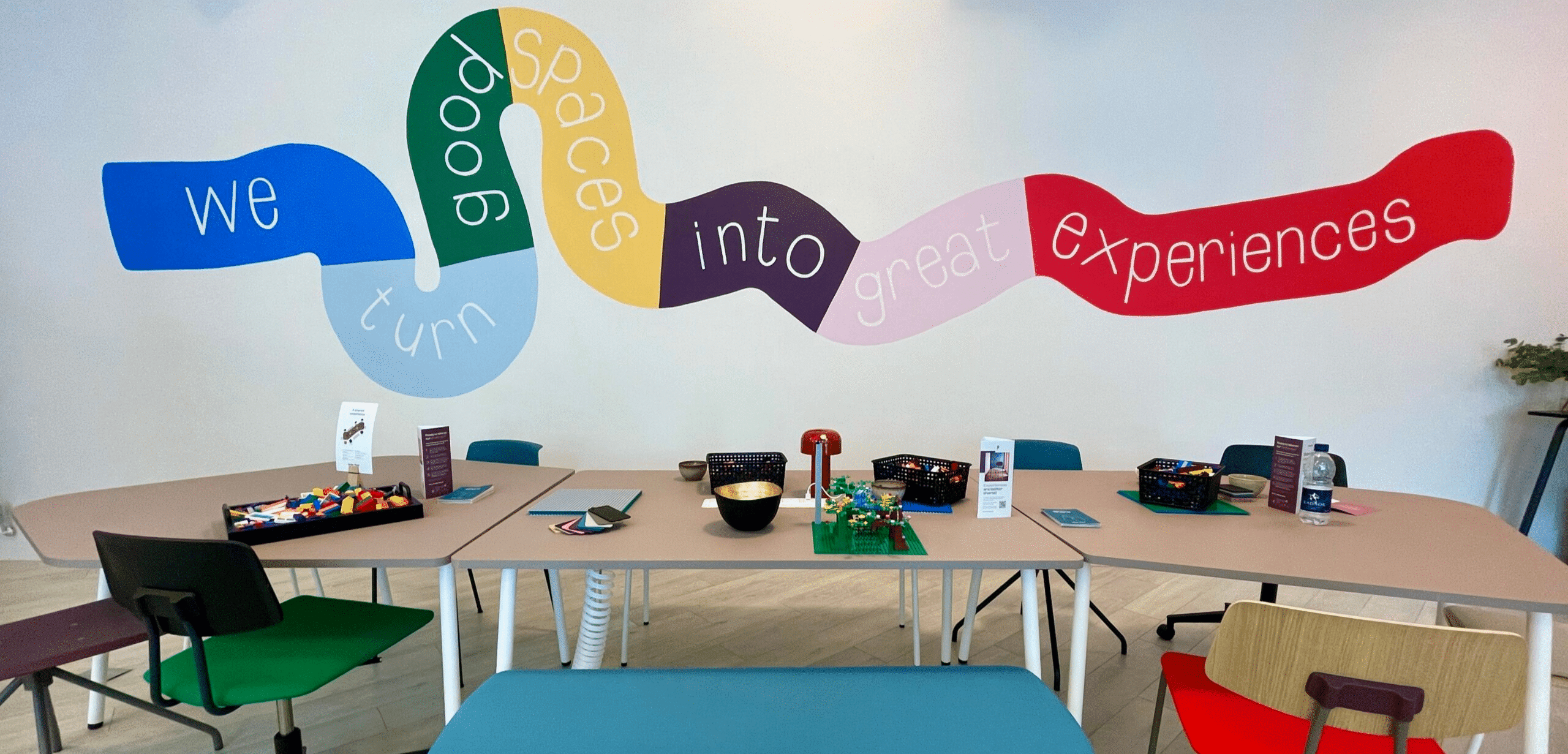 A room with colourful chairs and a colourful wall.