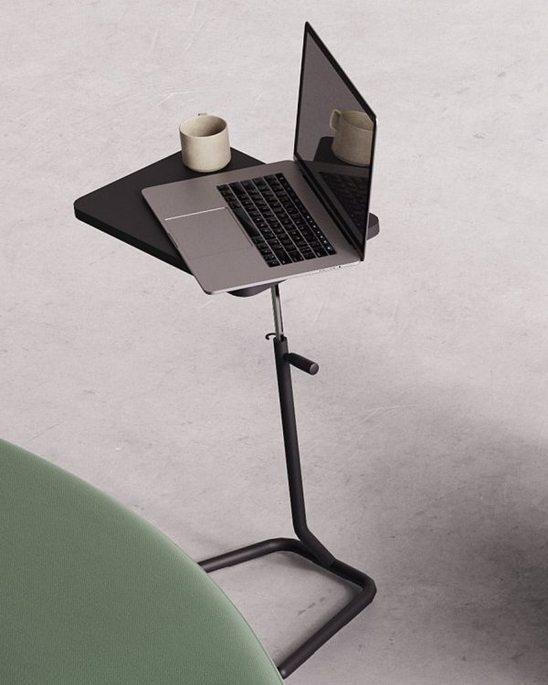 A laptop on an adjustable stand next to a green couch.