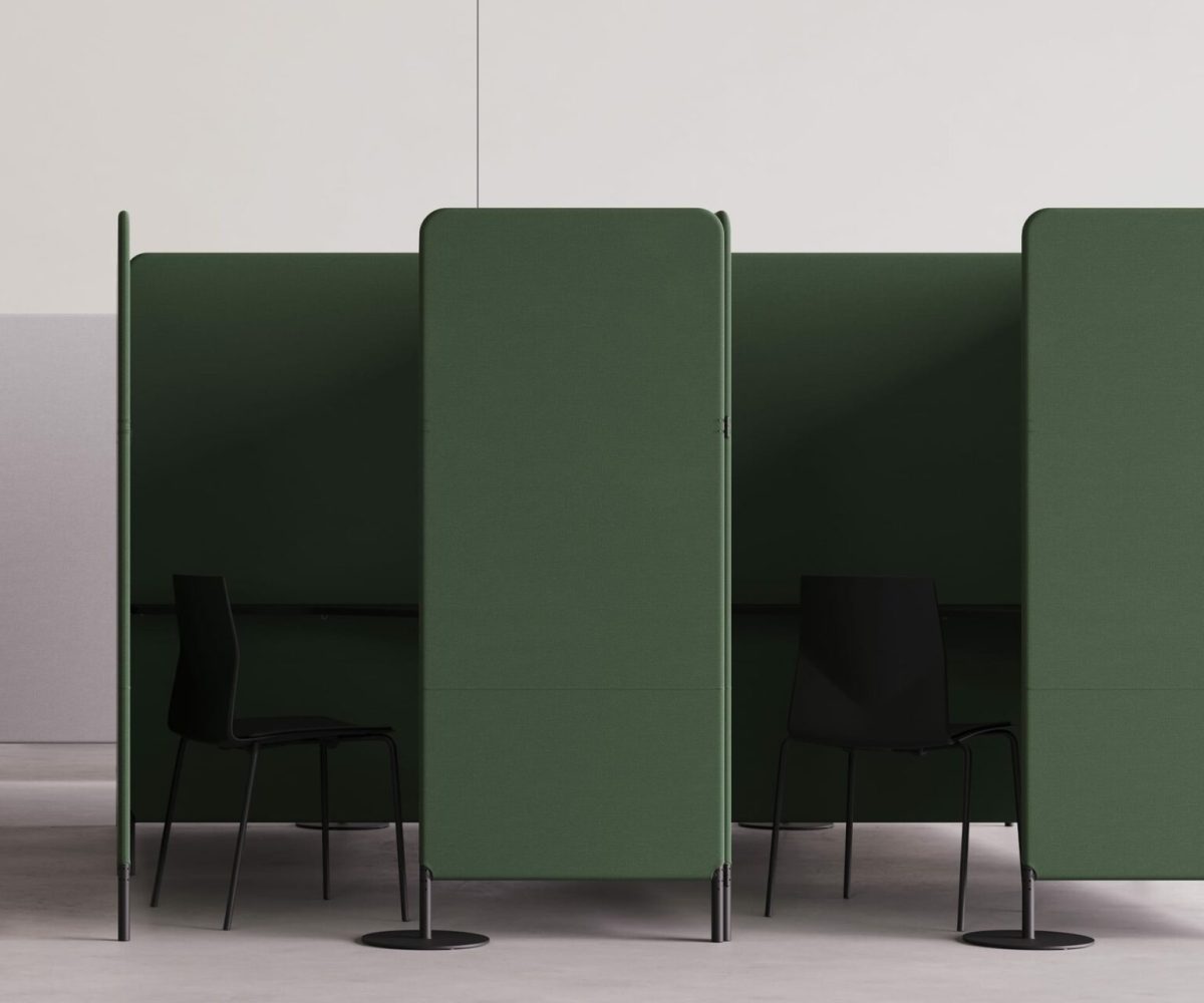 A green office cubicle with two chairs and a desk.