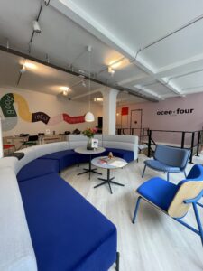 An office with a modular seating blue couch and blue lounge chairs for office.