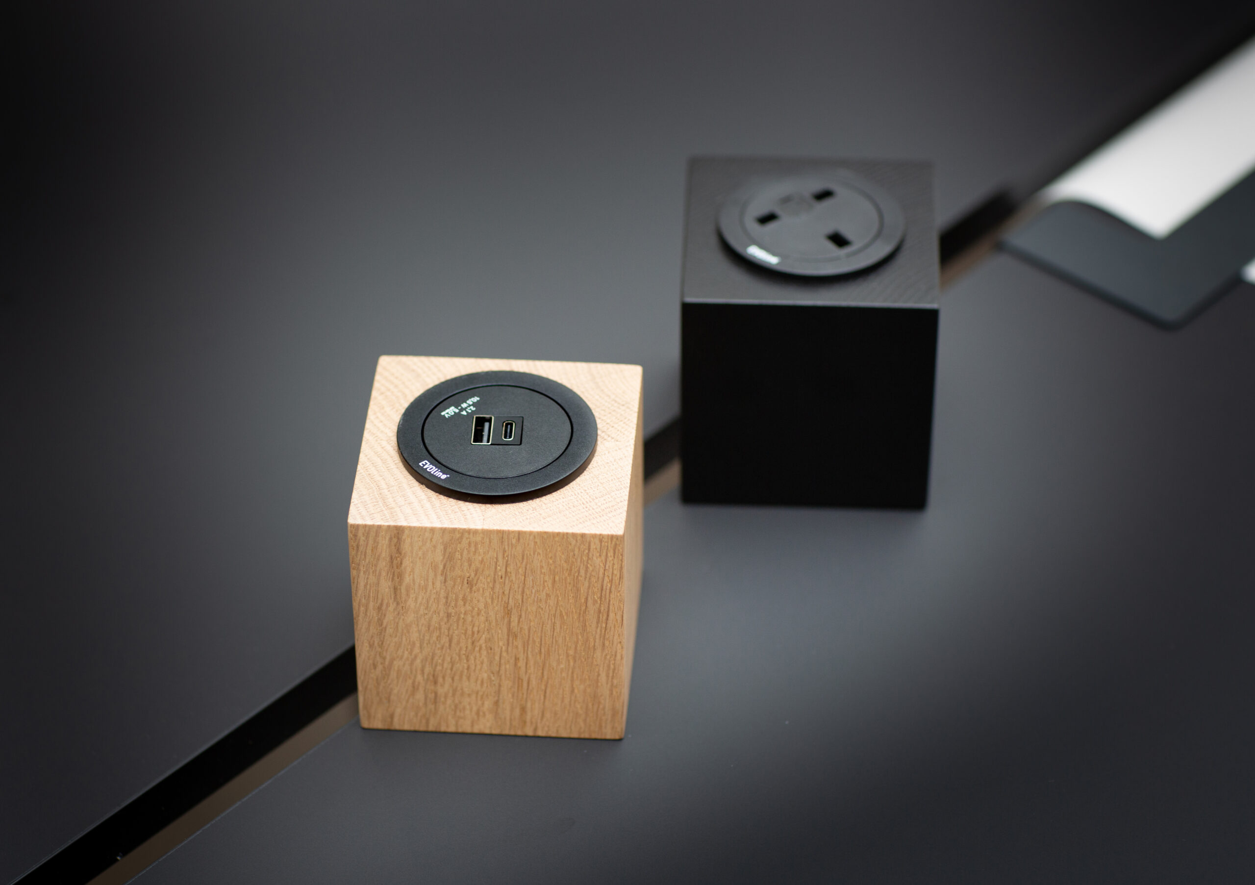 An oak and a black power cube on a table