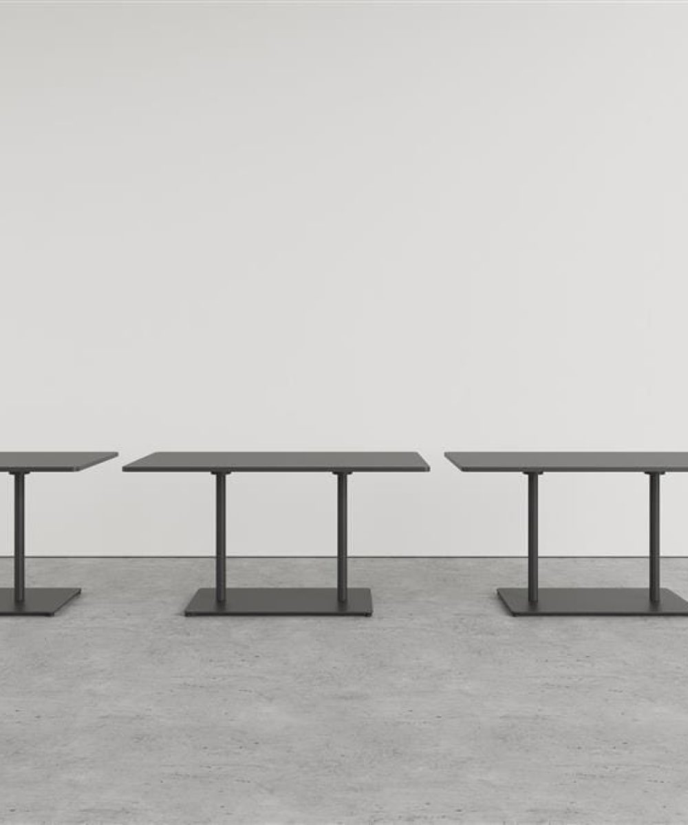 Three black pedestal tables in front of a white wall.
