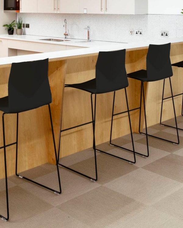 Four black bar counter height chairs in a kitchen against a counter