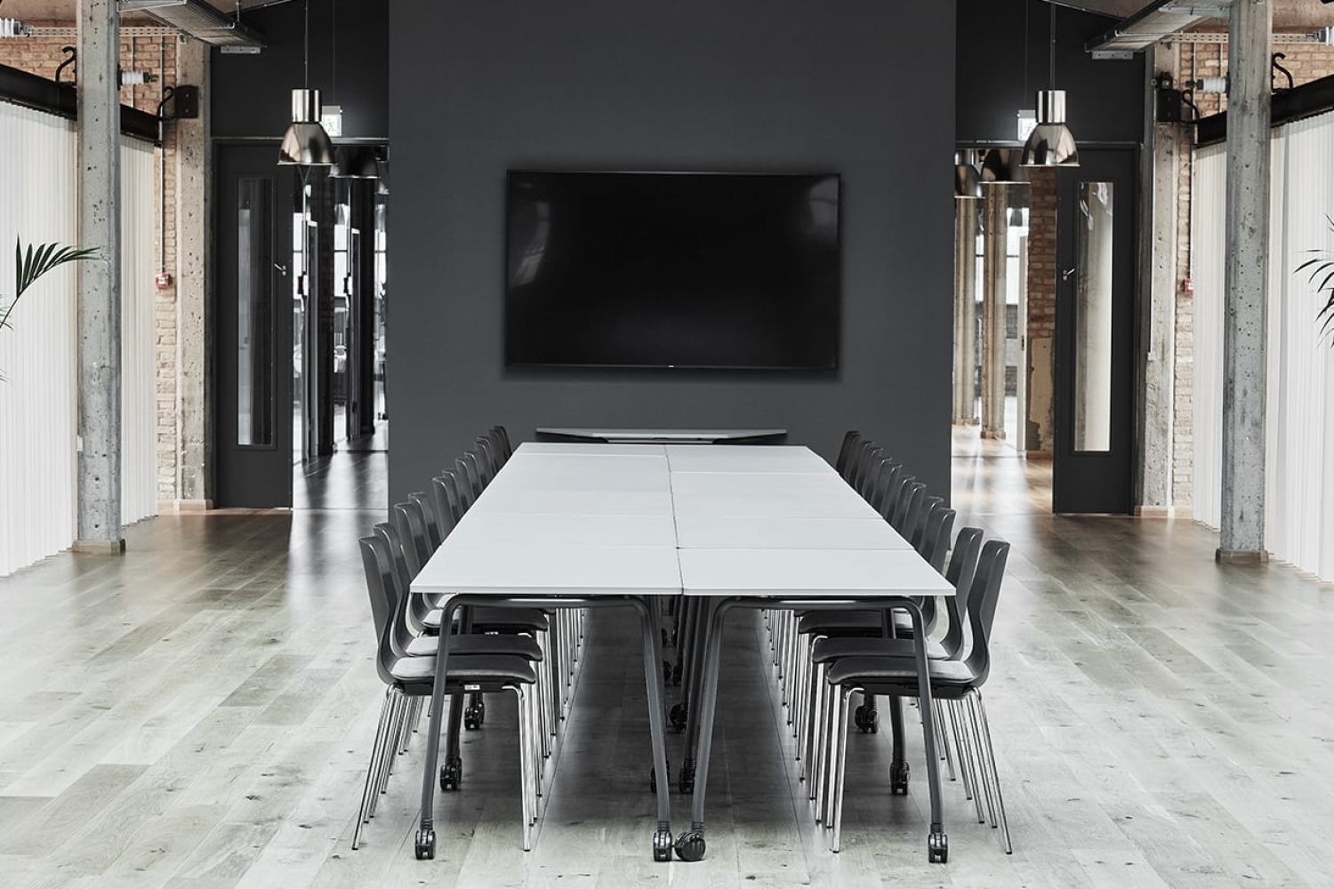 A black and white conference room with tables and office desk chairs.