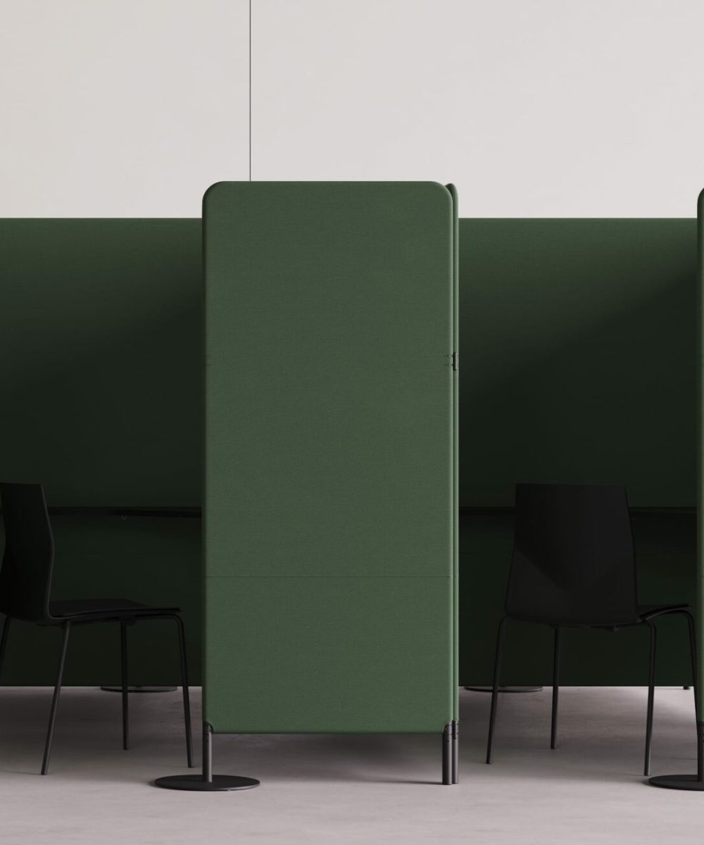 A green office cubicle with two chairs and a desk.