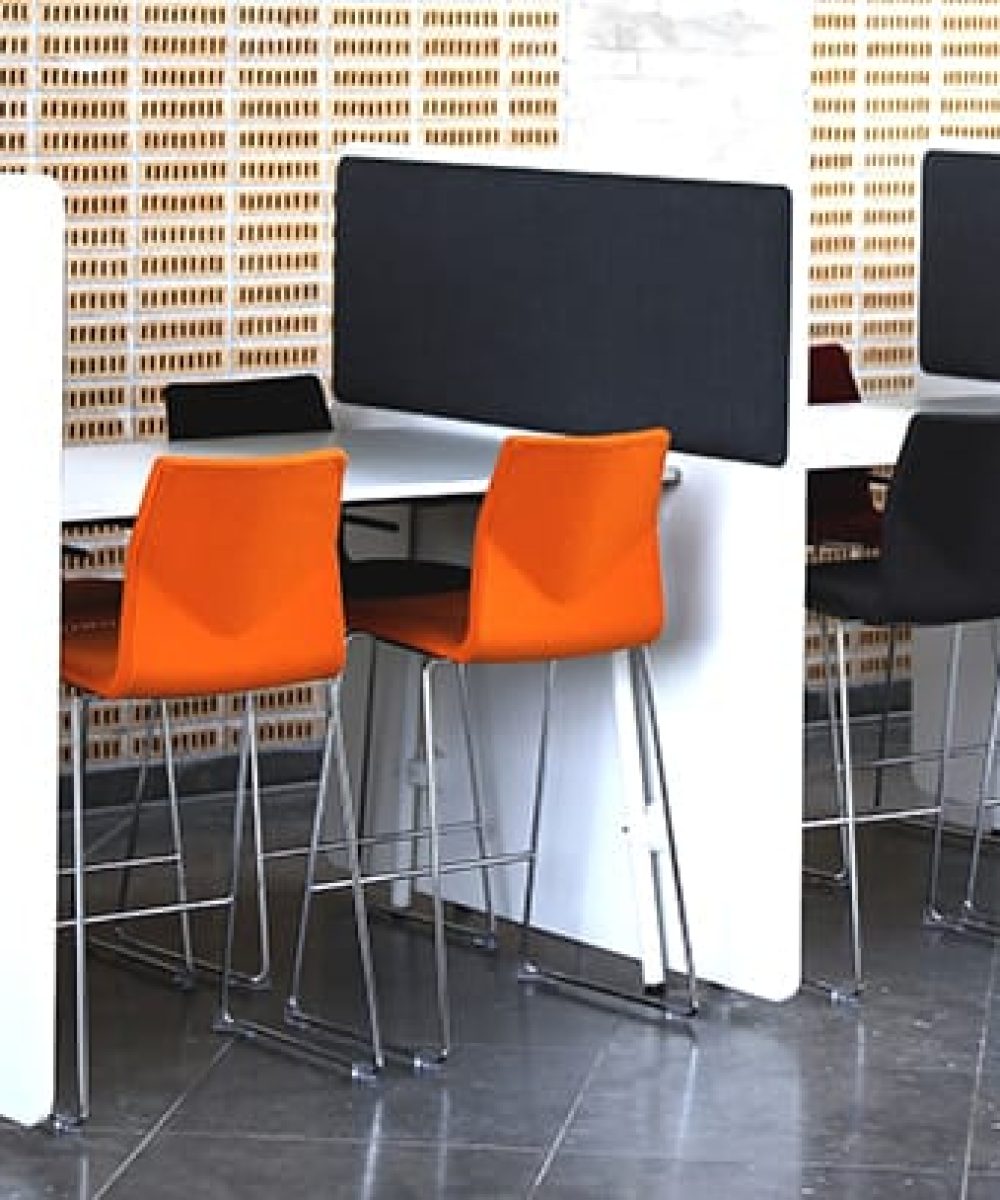 A group of chairs and tables with office screen dividers in a conference room.