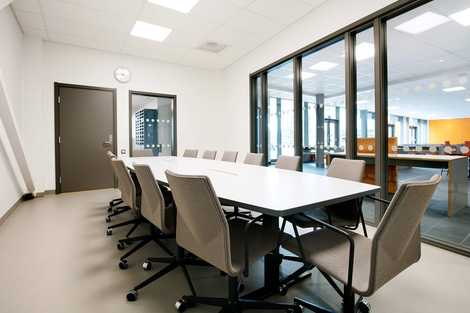 A conference room with a large conference table and office desk chairs.