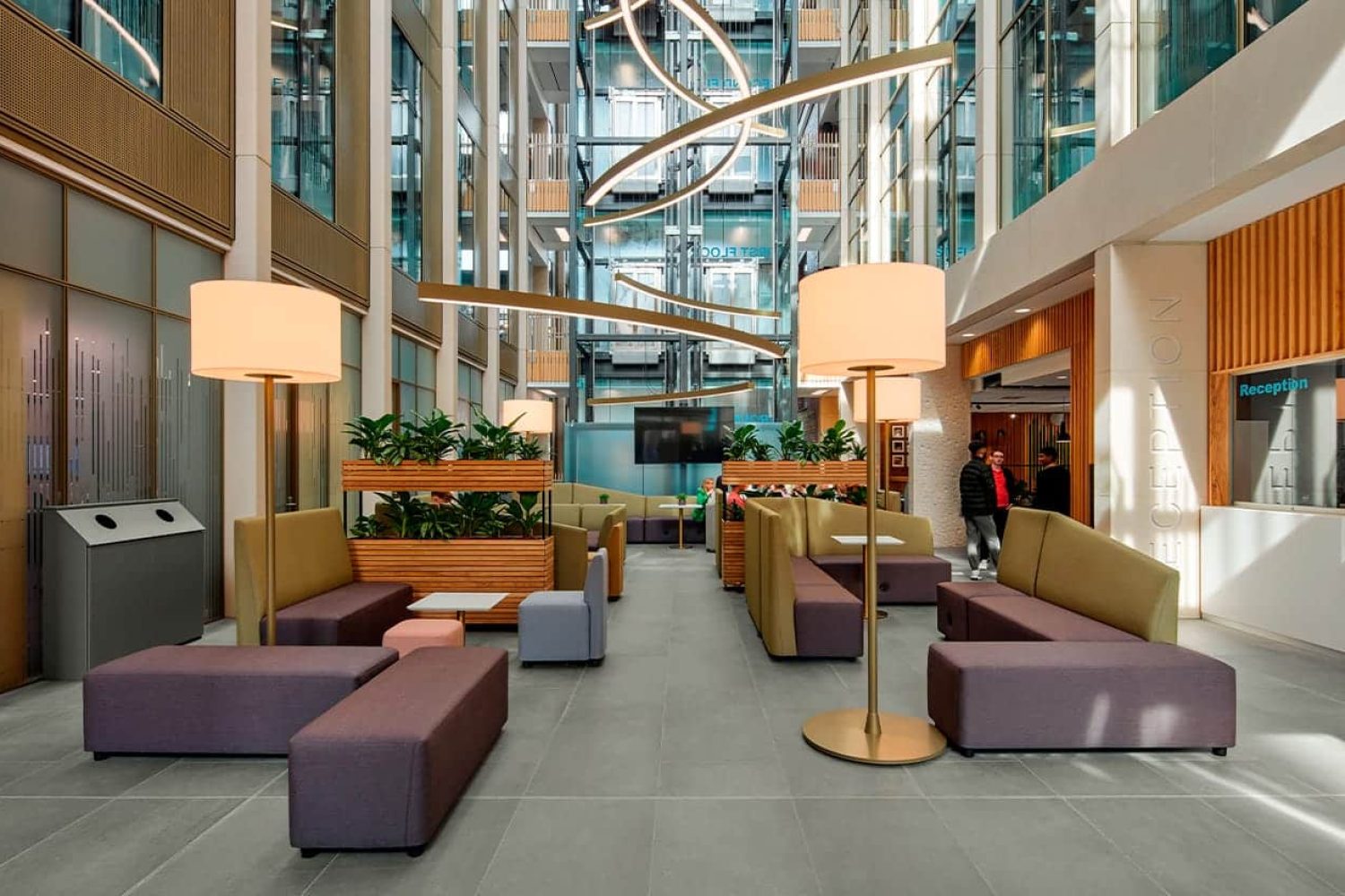 The lobby of a modern office building with office furniture in it. 