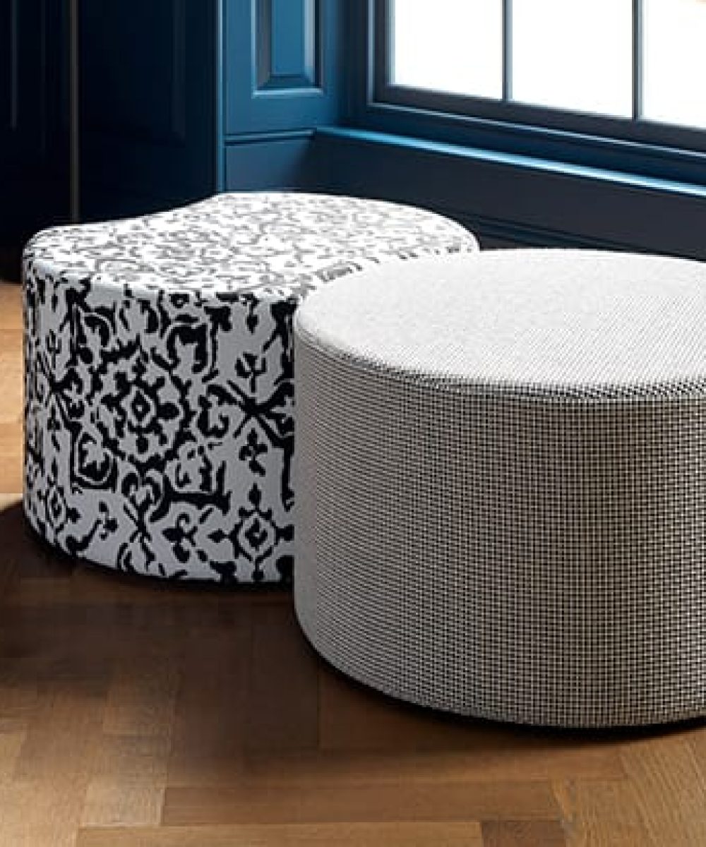 A black and white ottoman sitting on a wooden floor.
