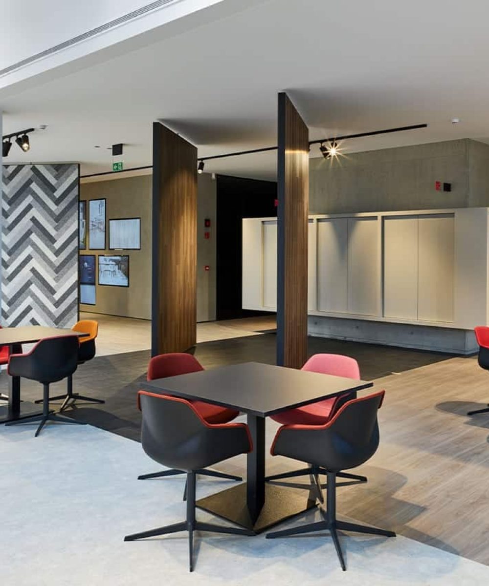 An office with pedestal tables and chairs in the middle of a large room.