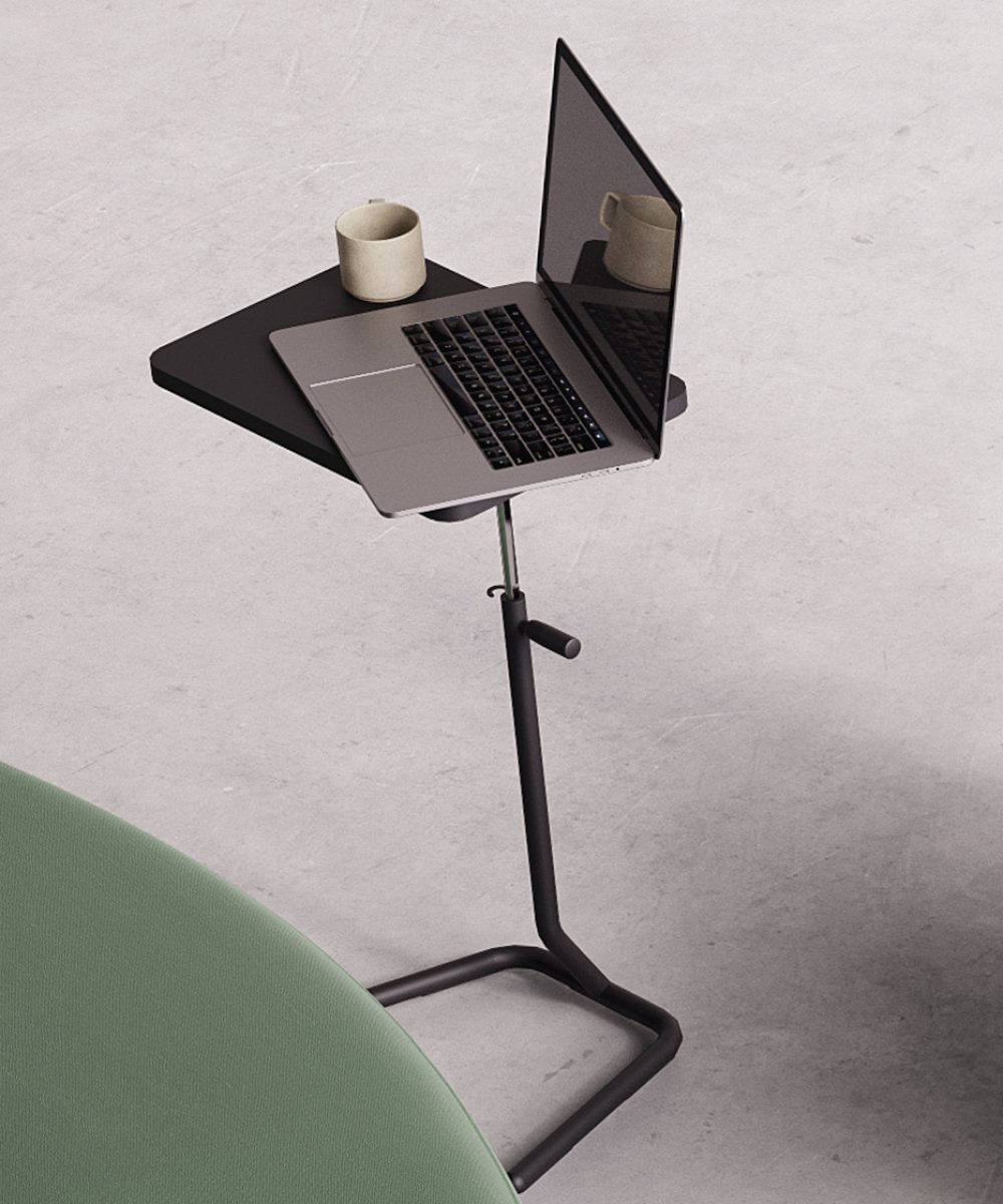 A laptop on an adjustable stand next to a green couch.